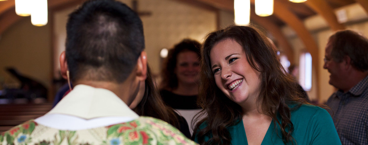 a woman speak with father lam le following mass at saint john paul ii parish in cedar springs, michigan