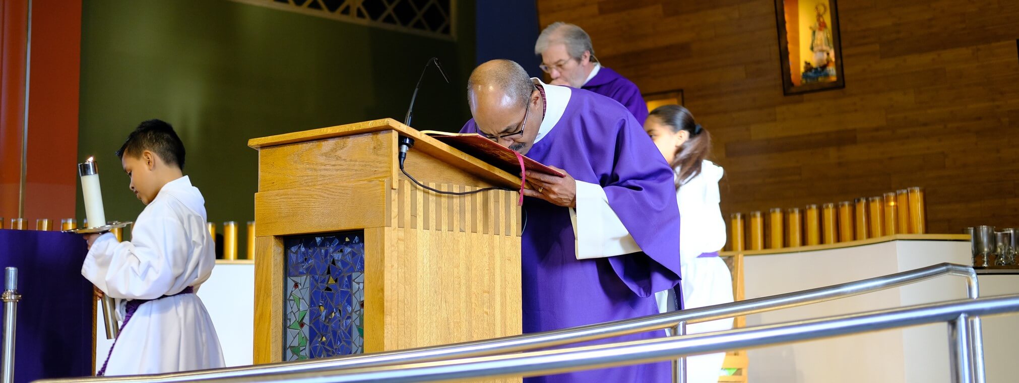 Deacon Carlos Guiterrez kisses the Book of Gospels after the Sunday reading at Saint Joseph the Worker parish