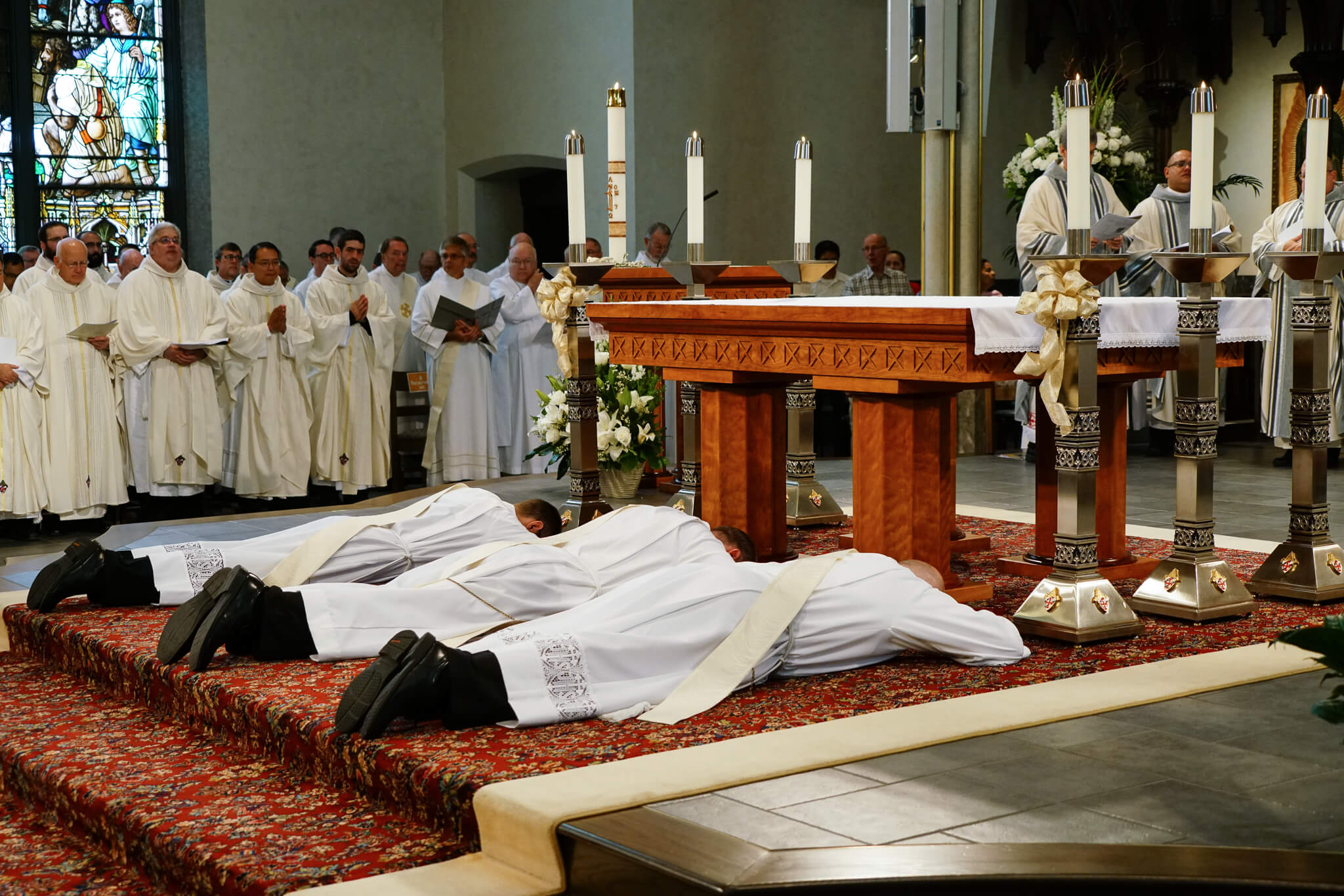 The men to be ordained lay prostrate on the cathedral altar