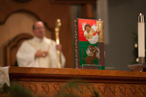 Image of the book of gospels with Bishop Walkowiak in background, Christmas midnight Mass 2016 by Eric Tank