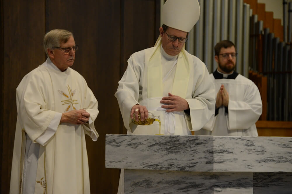 Bishop Walkowiak pours holy oil onto the altar during dedication Mass for St. John Paul II Church, Cedar Springs
