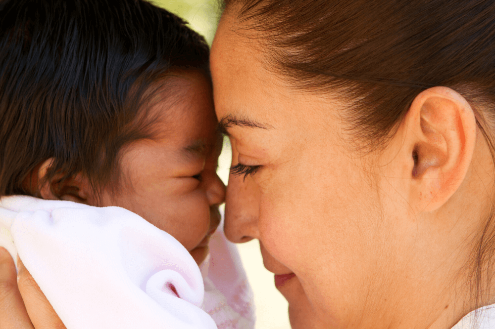 Mom holds baby face to face, rubs noses