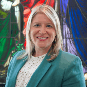 Sarah Grey headshot in front of stained glass window