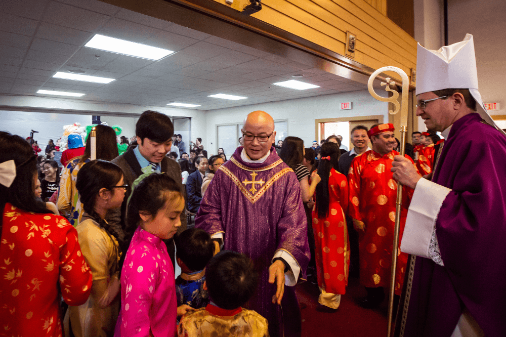 Bishop Walkowiak visits with Our Lady of La Vang parish community following Mass in 2015